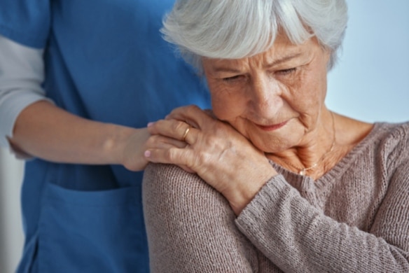 Nurse consoling a patient in dementia care