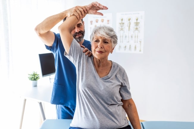 Nurse assisting a senior woman with short-term rehabilitation